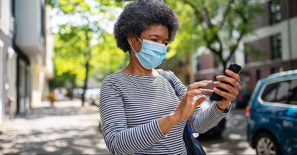 Masked Black Woman holding cellphone